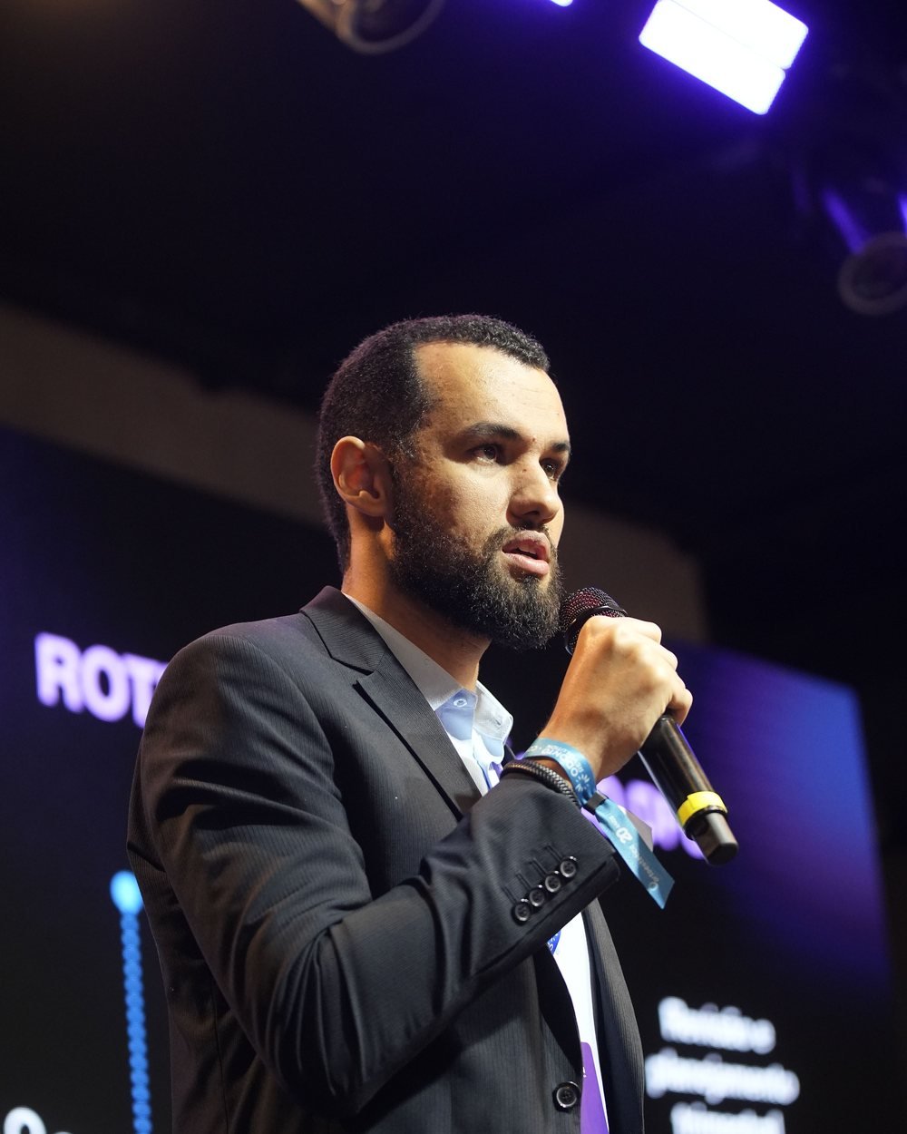 Lucas Soares palestrando com microfone no palco